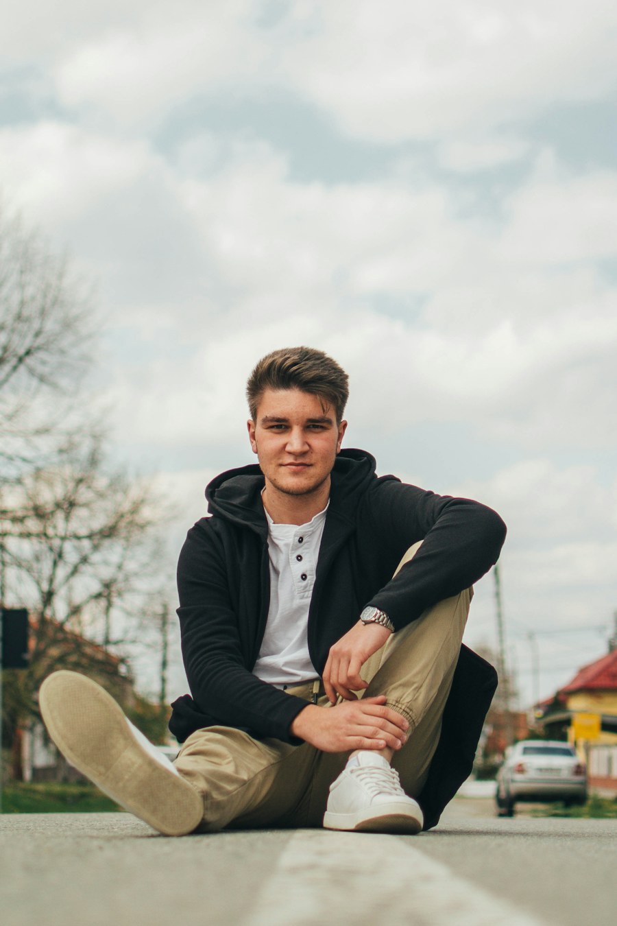 Young man sitting on the ground outdoors